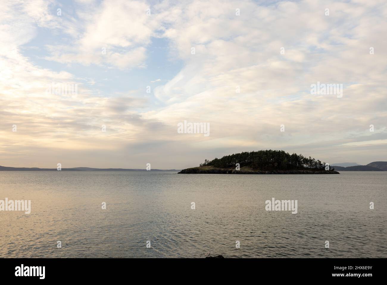 sunlight streaming through clouds reflecting in calm ocean Stock Photo