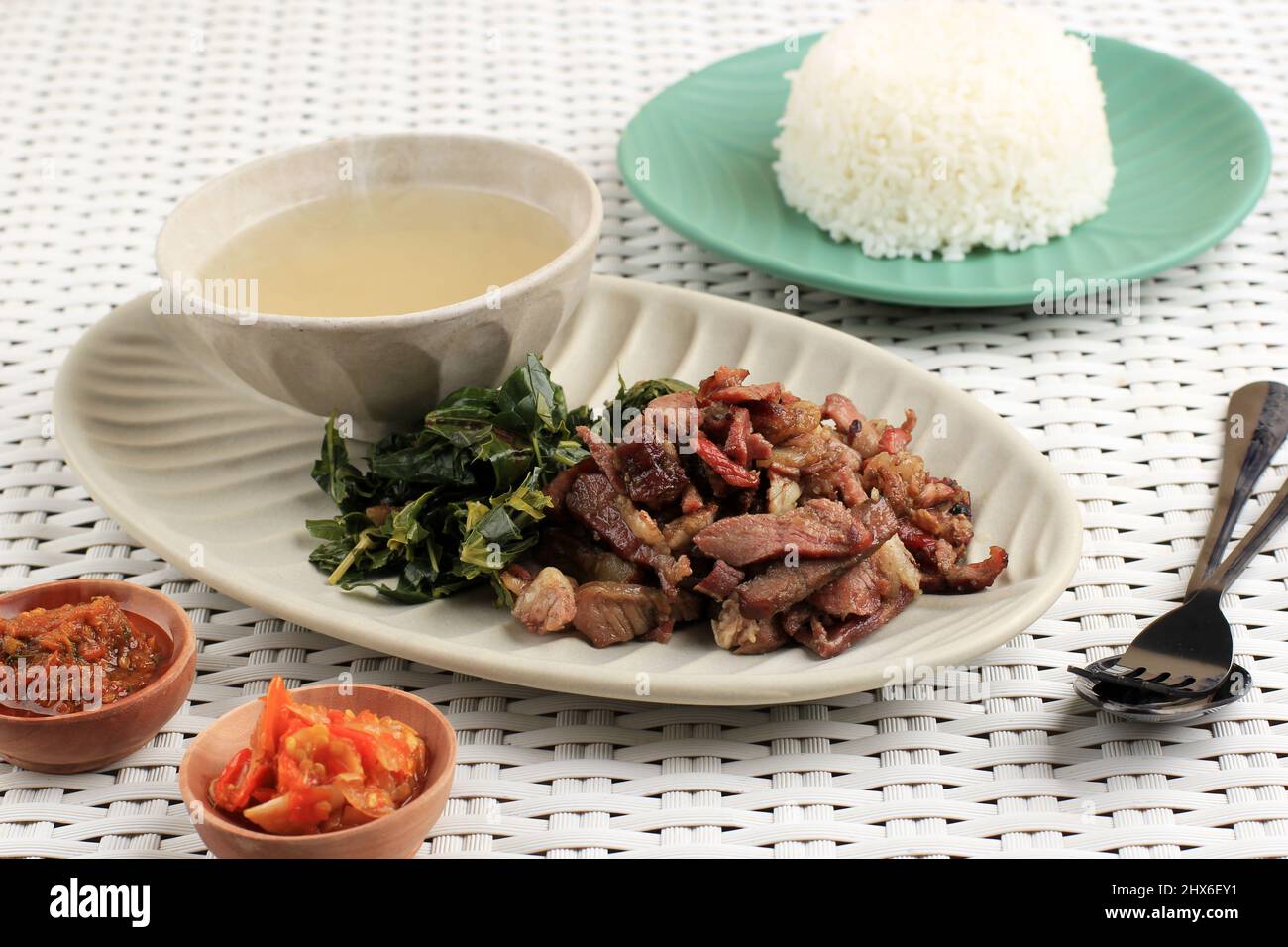 Se'i Sapi or  Beef Sei is Indonesia Traditional Smoked Beef, Served with Boiled Cassava Leaves and Sambal Luat or Sambal Matah. Typically Food from Nu Stock Photo