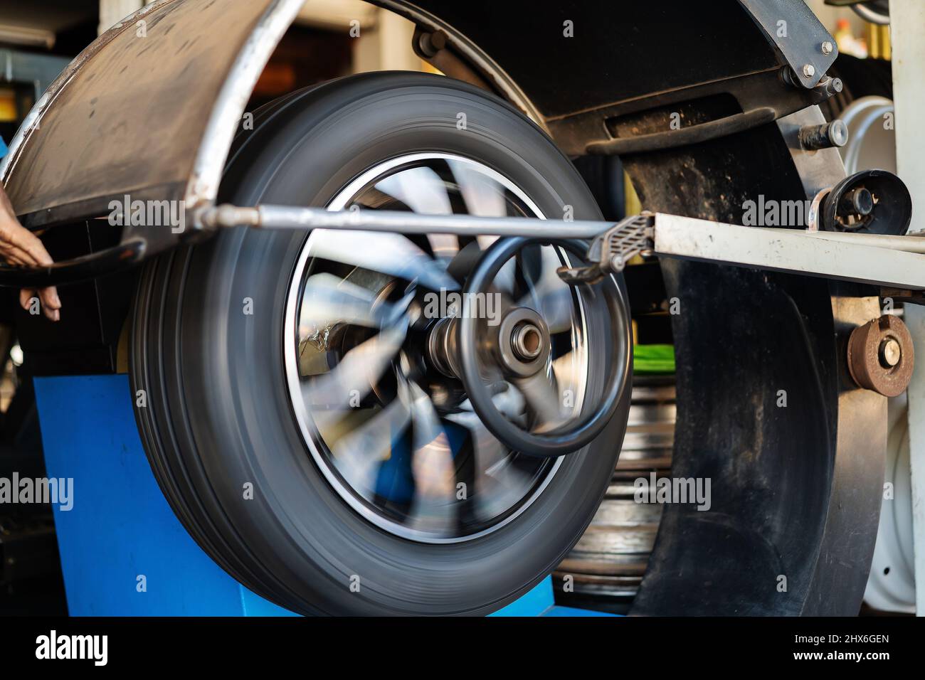 mechanic man balancing a car wheel on an automated machine Stock Photo