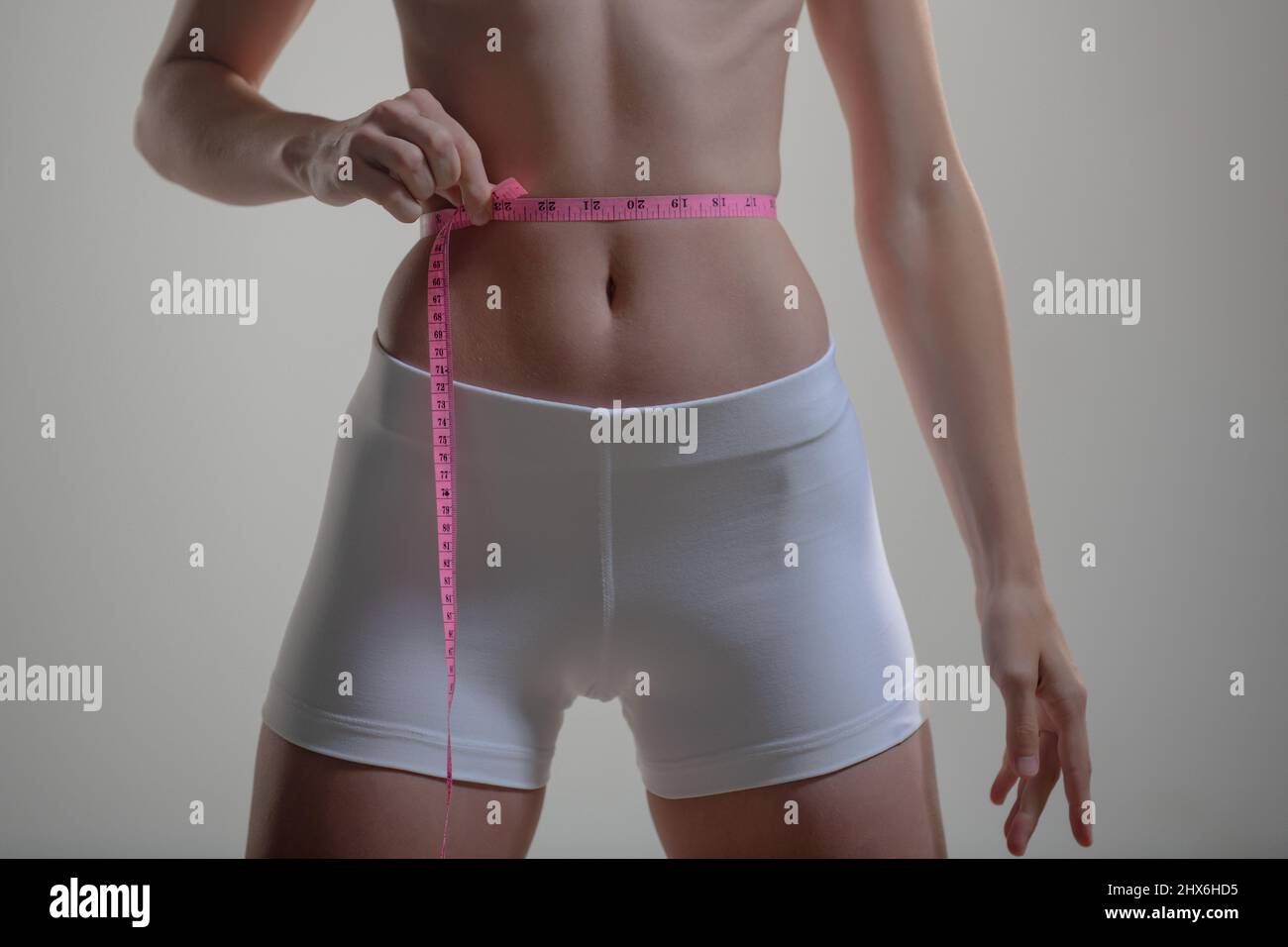 https://c8.alamy.com/comp/2HX6HD5/slim-girl-holding-a-centimeter-around-the-waist-line-slim-young-woman-measuring-her-waist-with-a-tape-measure-weight-los-2HX6HD5.jpg