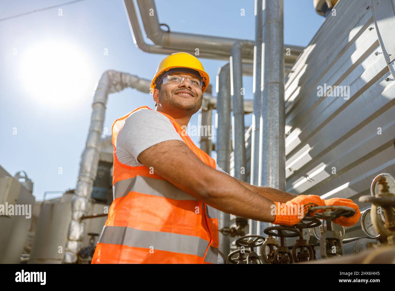 Smiling young construction engineer working in plant Stock Photo