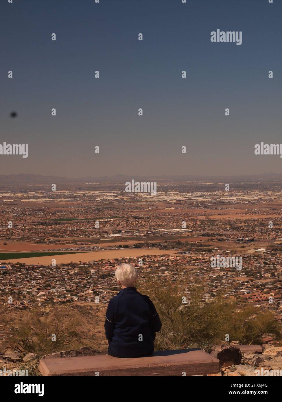 Woman sitting at Dobbins Lookout at the South Mountain Park and Preserve in Phoenix, Arizona. Stock Photo