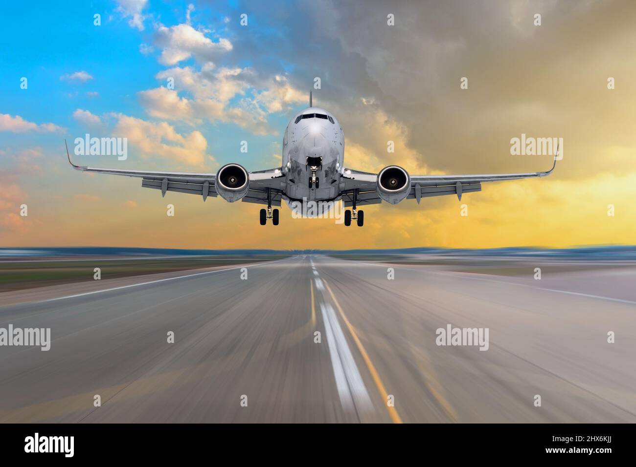 Airplane flying arrival landing on a runway in the during a bright sun