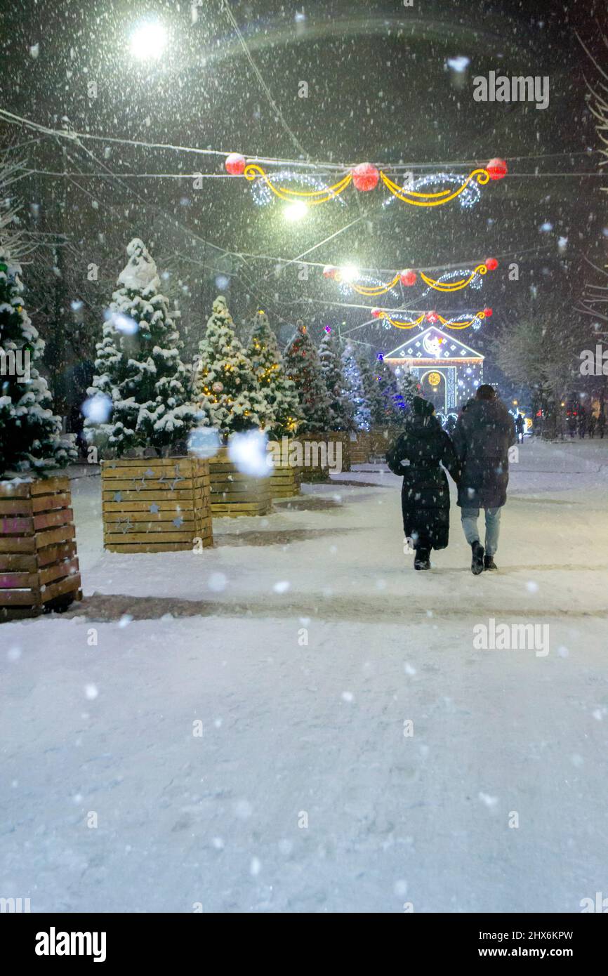 Snowy city street with Christmas trees and illumination decoration Stock Photo