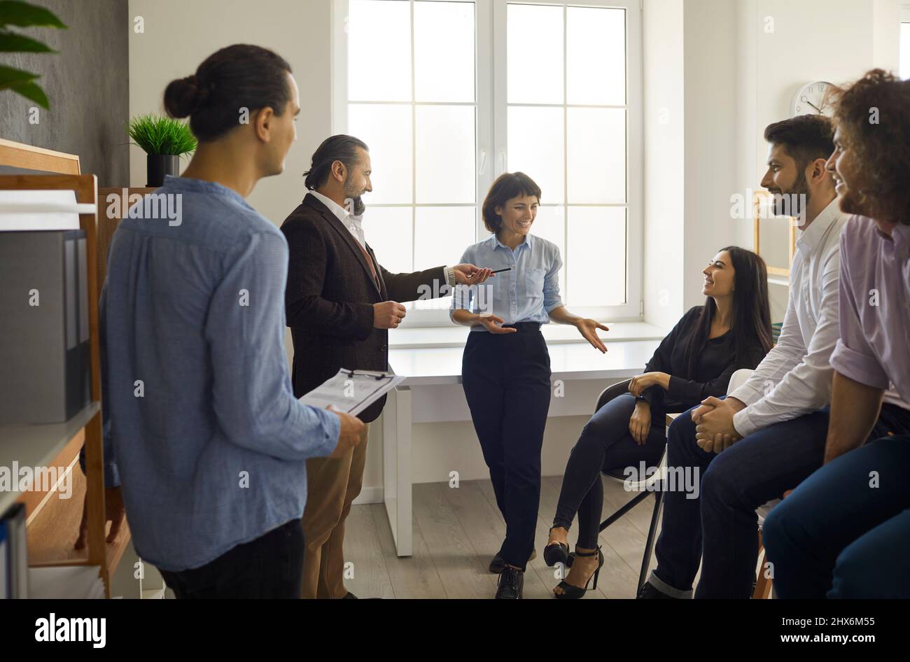 Employees communicate with each other by telling stories and discussing their work during the break. Stock Photo