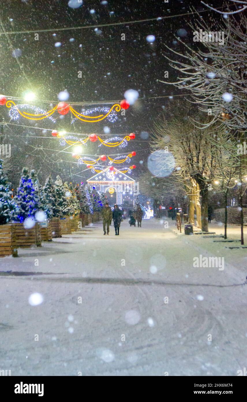 City street during snowfall at winter night. Stock Photo