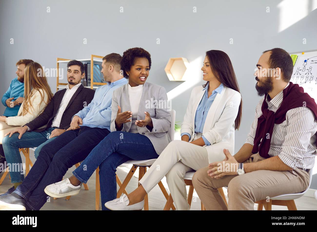 Diverse team of happy young people talking during business training meeting in office Stock Photo
