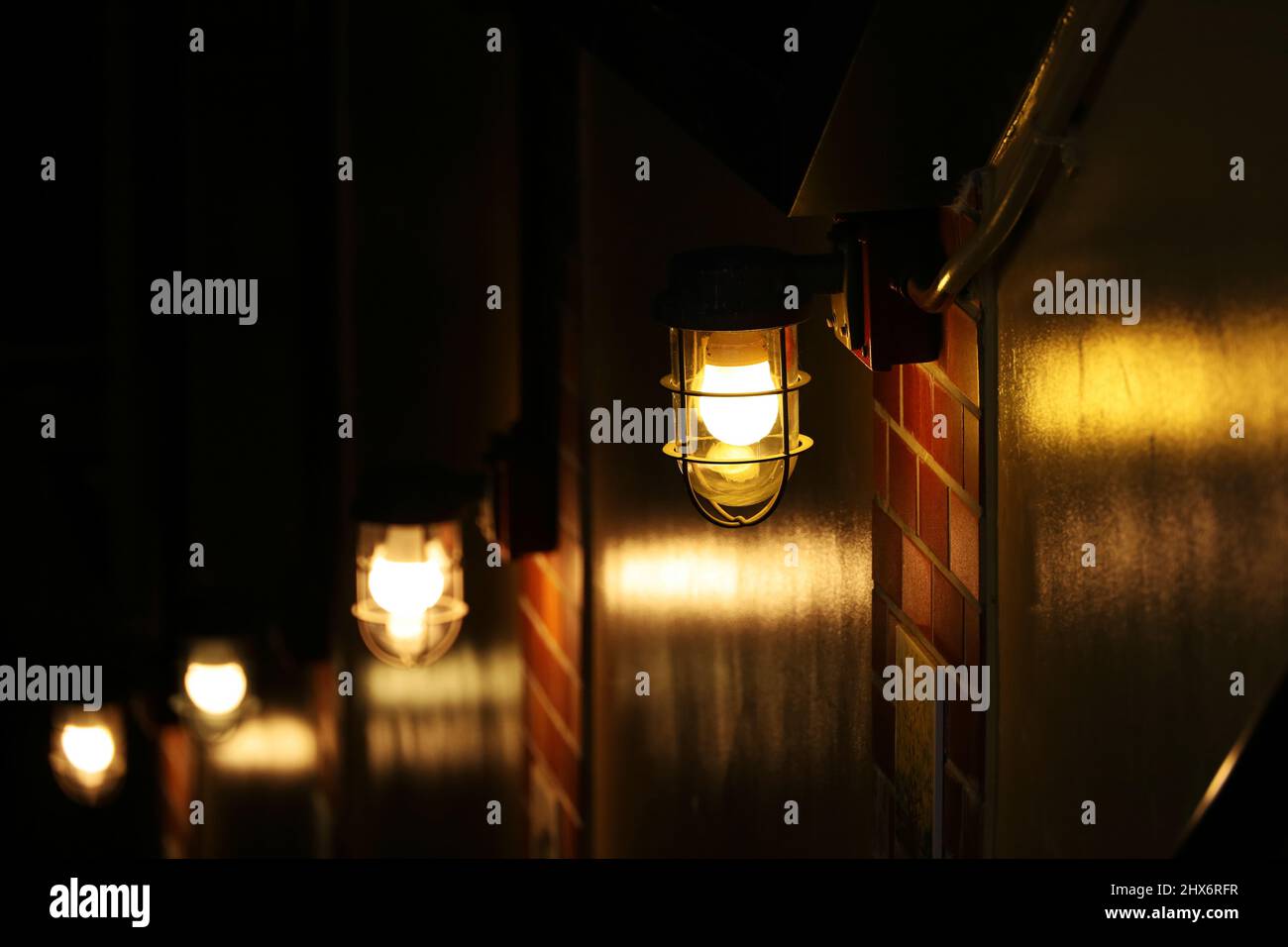 Ship lights lined up on the wall illuminating the stairs to the basement Stock Photo