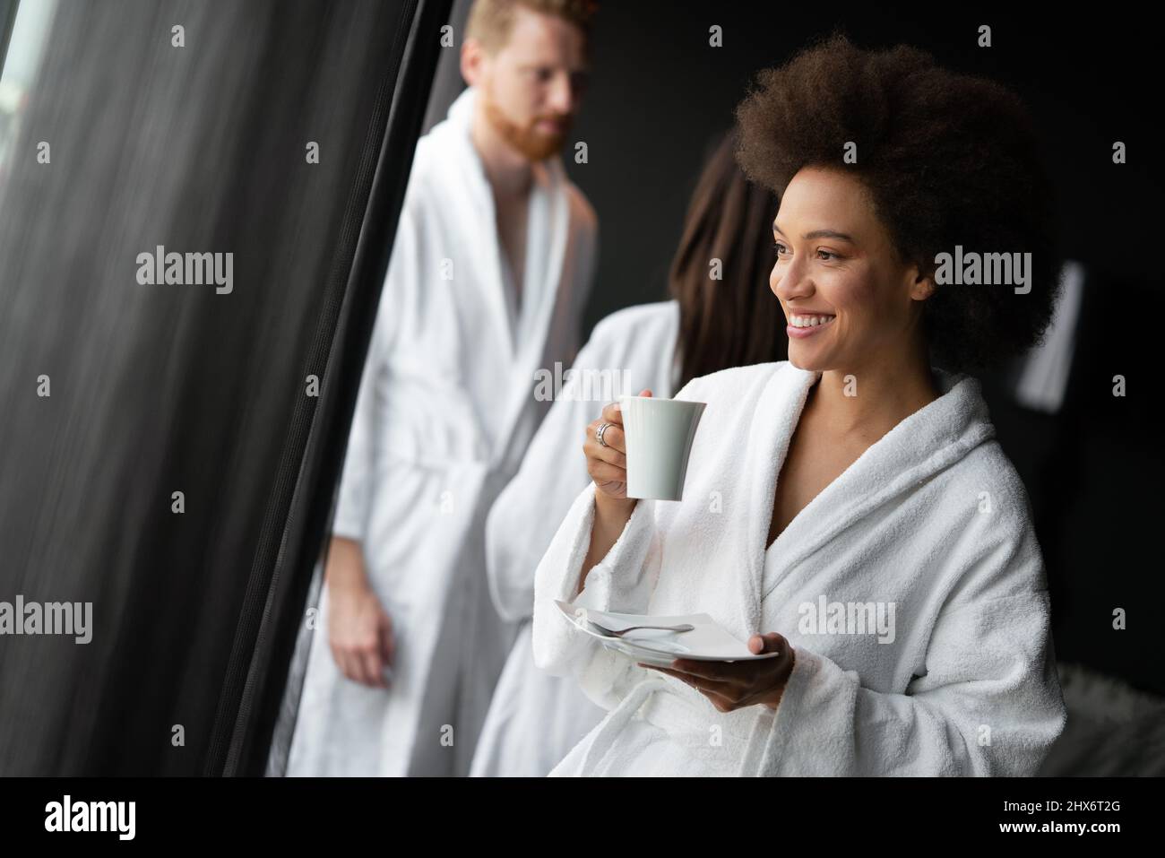 Portrait of a beautiful young woman drinking tea dressed in a bathrobe in a wellness spa center Stock Photo