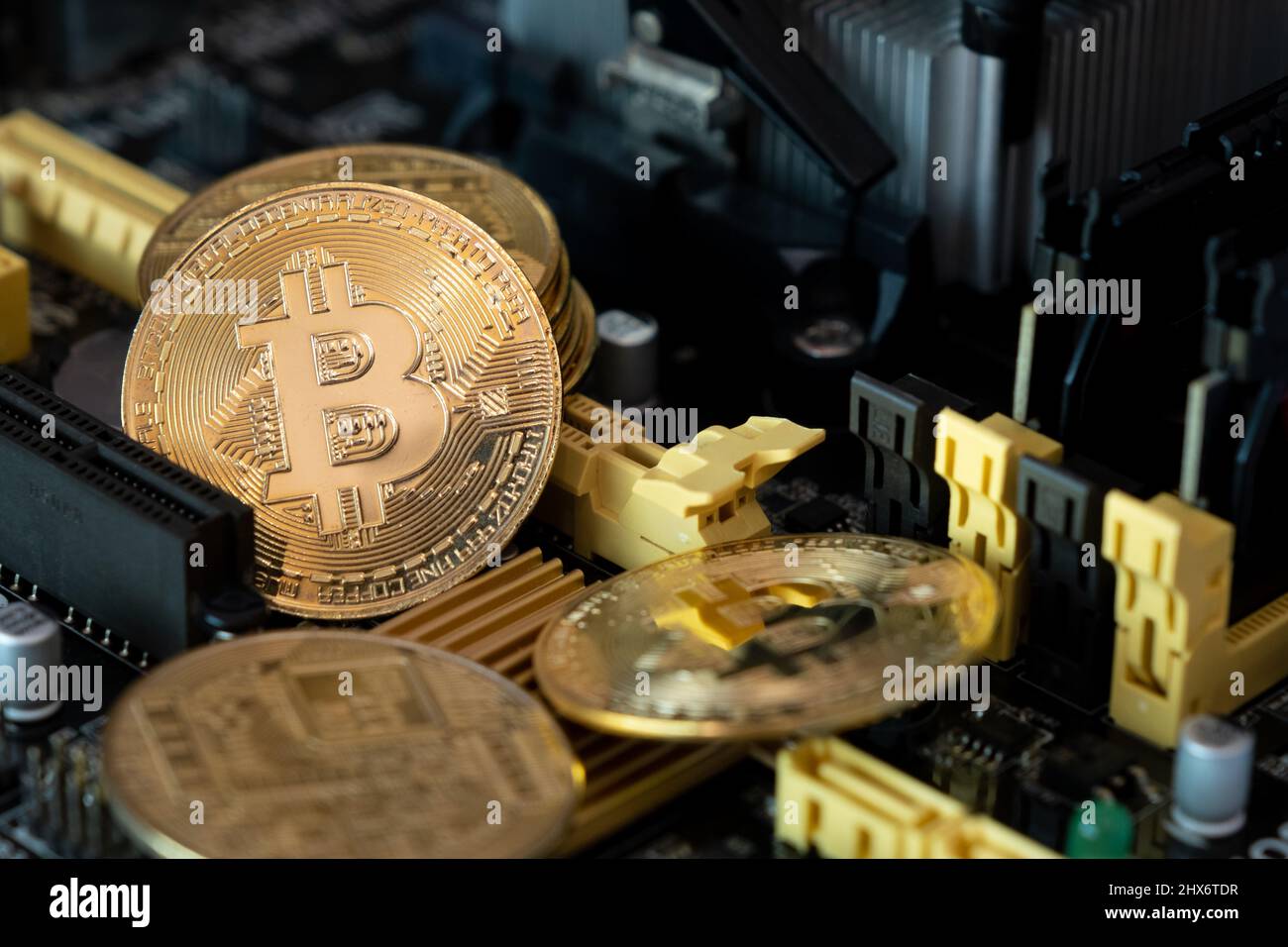 Golden bitcoins on a computer  main board . Crypto currency coins on  mother board background. Stock Photo