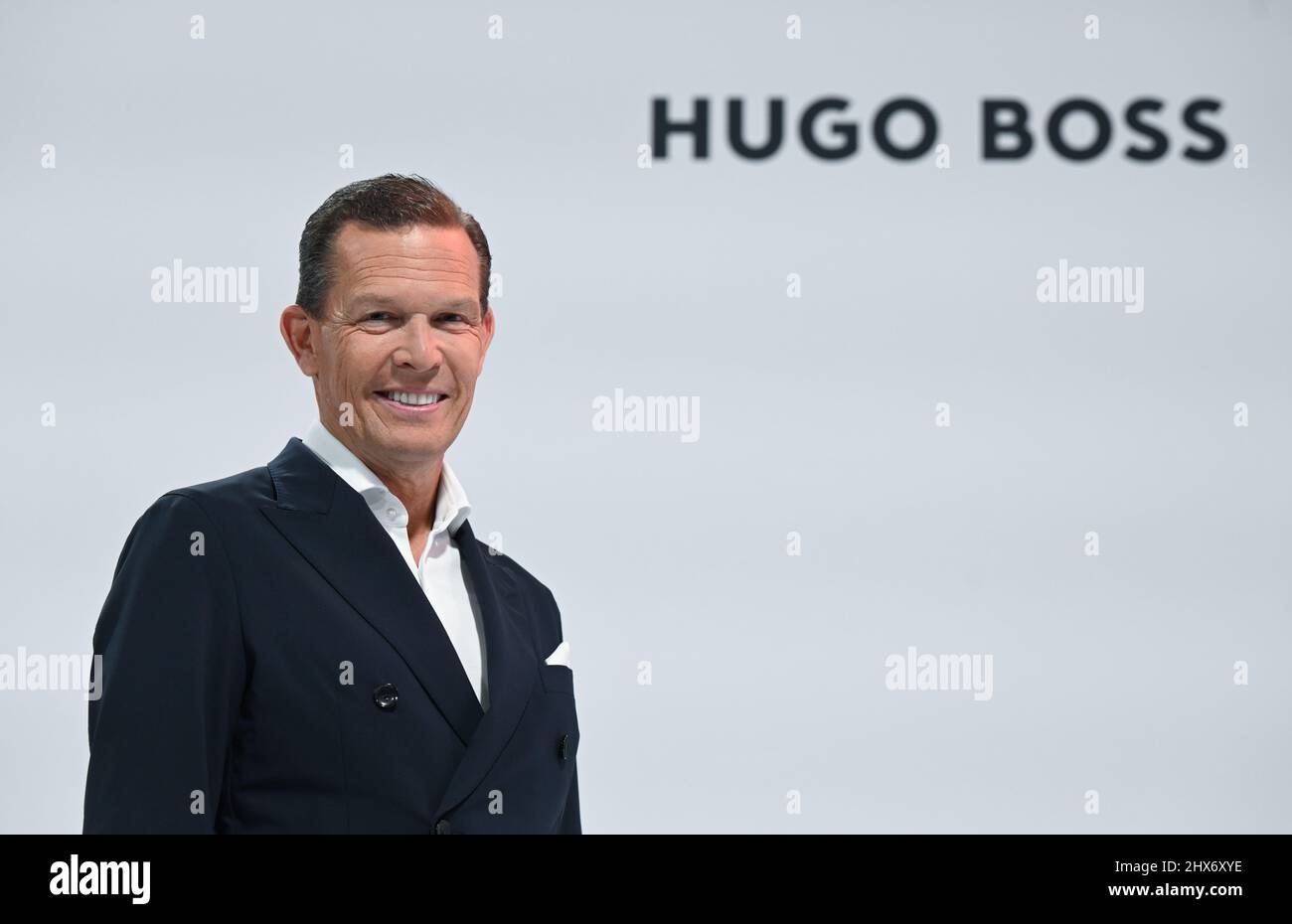 Filderstadt Sielmingen, Germany. 10th Mar, 2022. Daniel Grieder, CEO of  fashion group Hugo Boss, stands in front of a Hugo Boss logo before the  start of the annual press conference. Credit: Bernd
