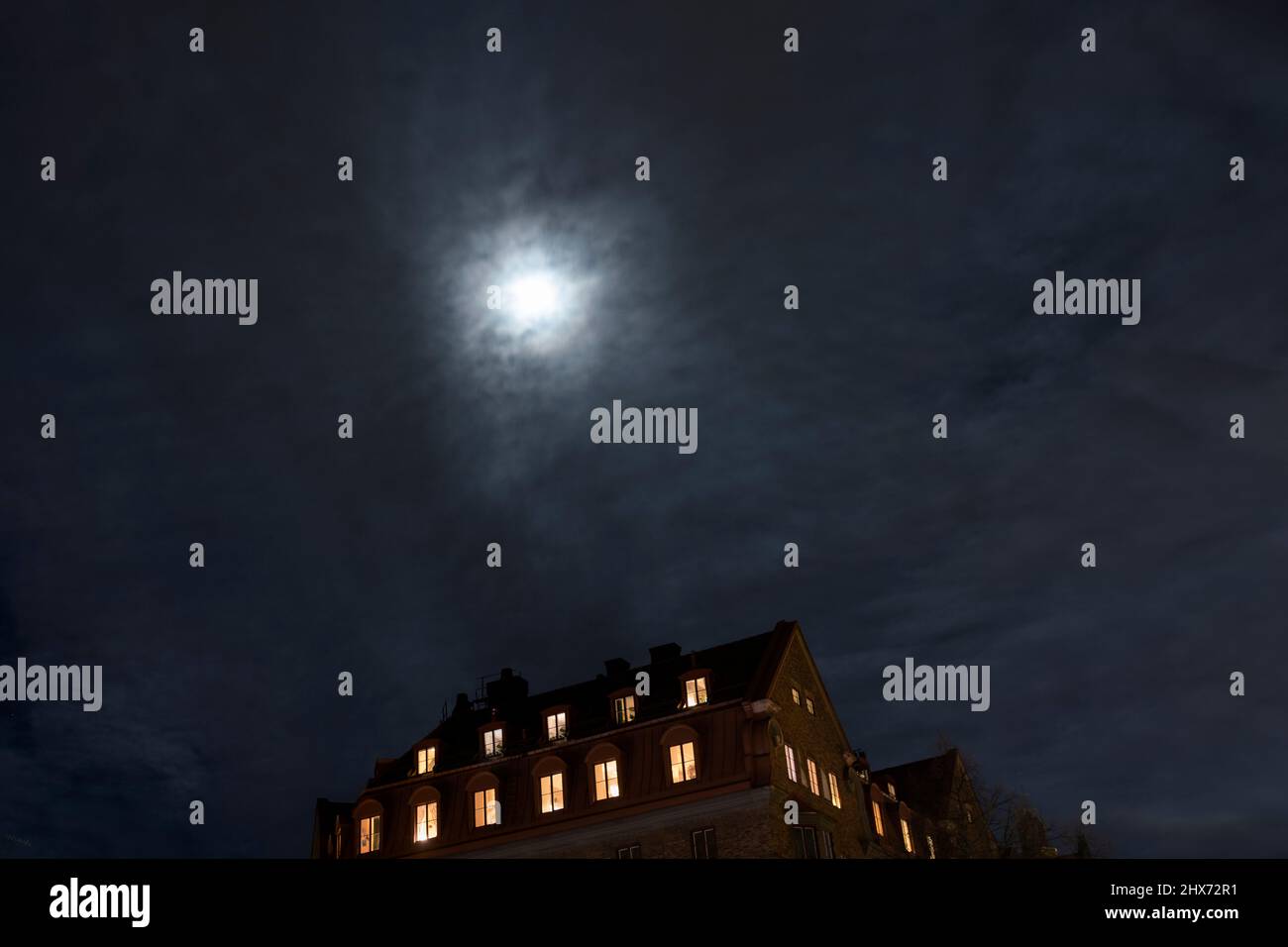 Moon over multistorey townhouses at night Stock Photo