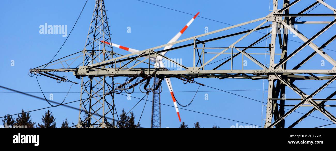 some high voltage cables in front of a wind turbine panorama Stock Photo