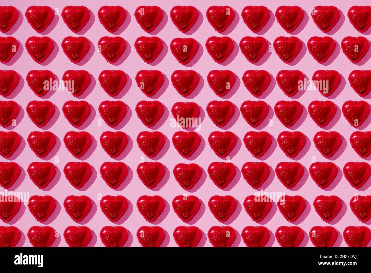 Heart-shaped candy on pink background Stock Photo - Alamy