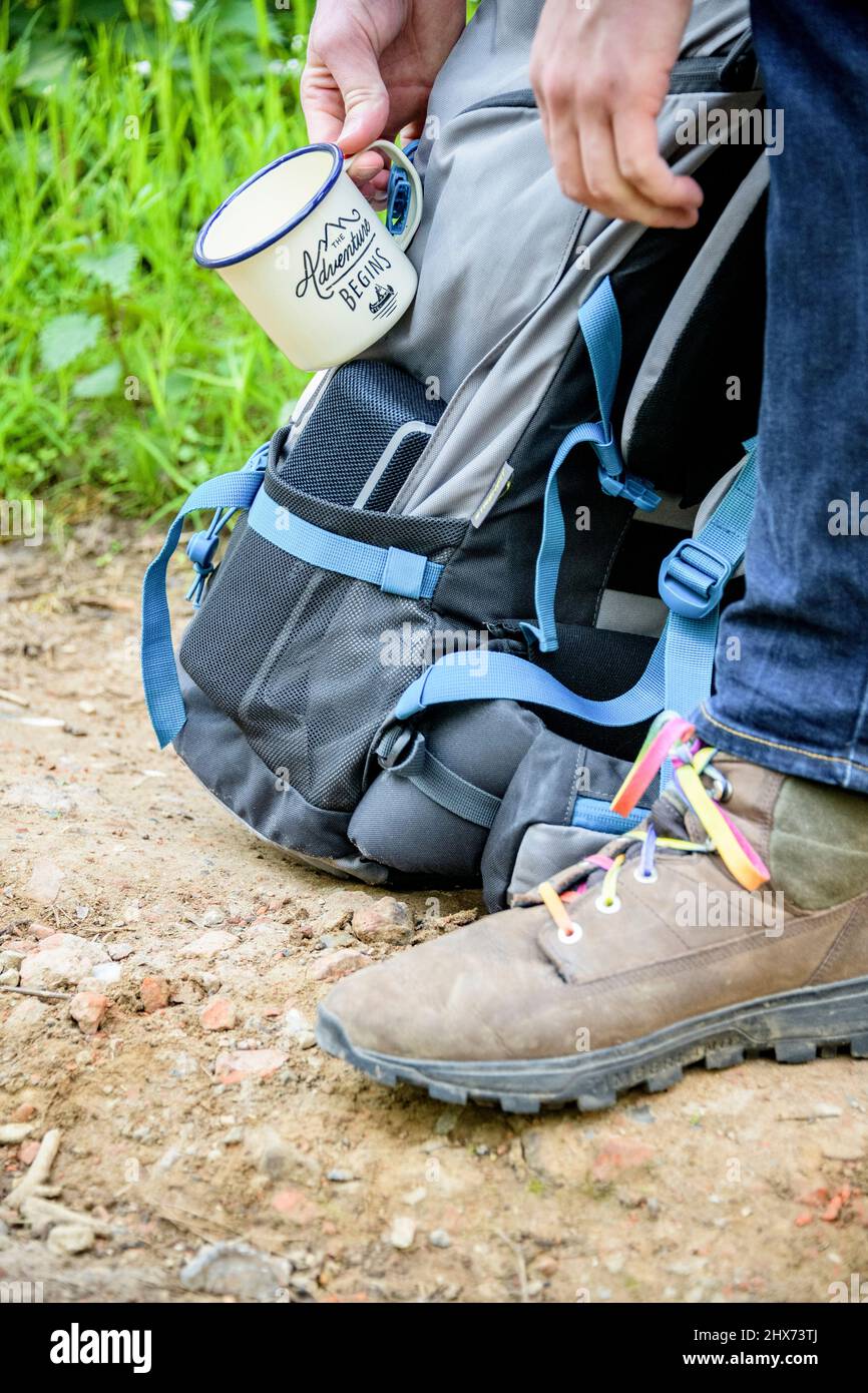 coffee mug hanging on hikers backpack Stock Photo