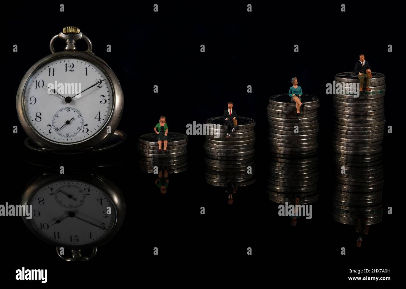 Miniature people: clock and people sitting on the stack of coins. Retirement planning. saving money and investment. Countdown to retirement and pensio Stock Photo