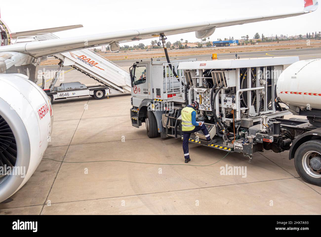 A worker employee refueling Iberia airlines Airbus A320 twin-engine jet aircraft airplane in Marrakesh Menara Airport, Morocco, North Africa Stock Photo