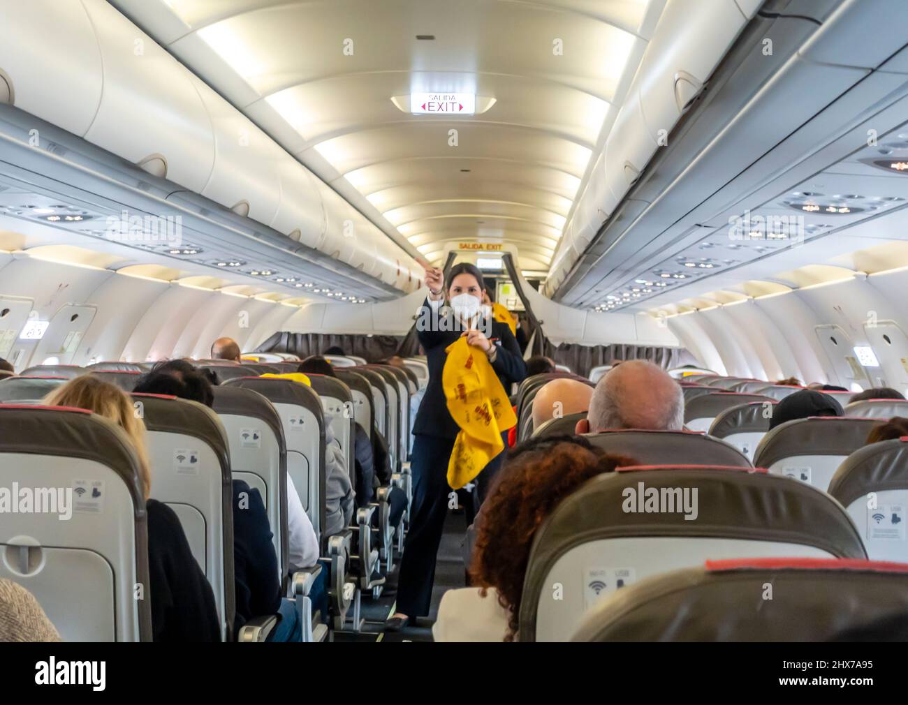Female flight attendants in face masks demonstrating evacuation