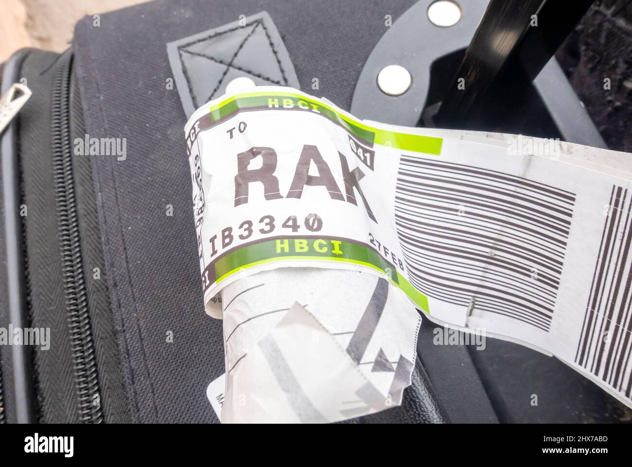 A suitcase with an airline baggage tag shows the three letter airport