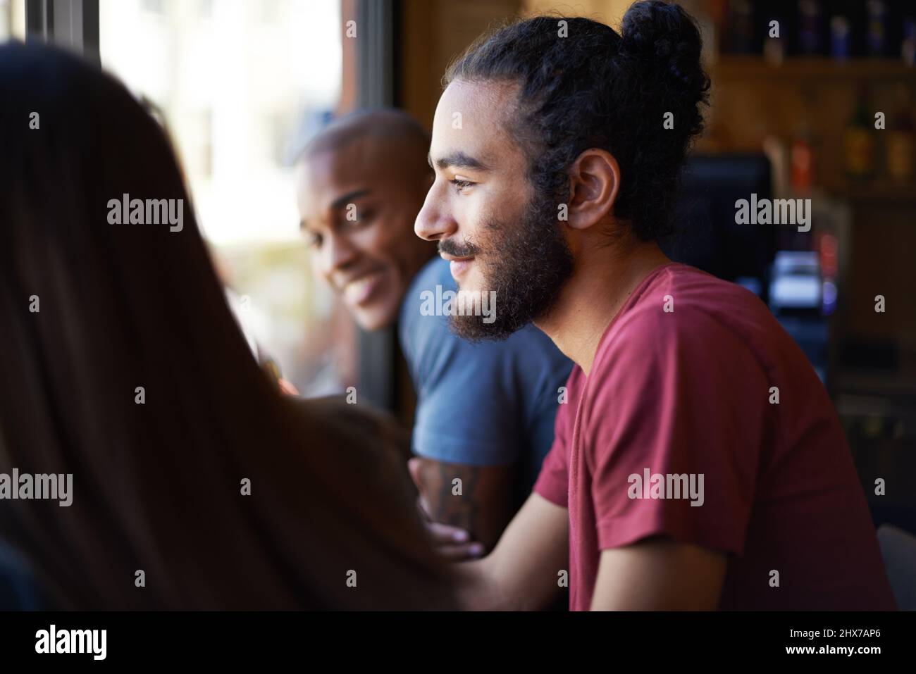 Friends and a cold one - life is good. A cropped shot of young friends socializing at a bar. Stock Photo