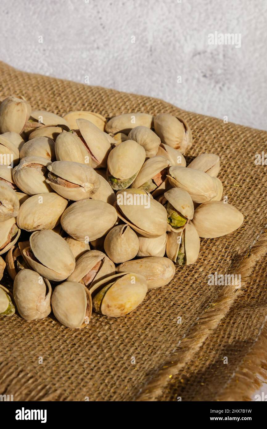 Pistachios in burlap sack on concrete table. Organic pistachios. Vegan