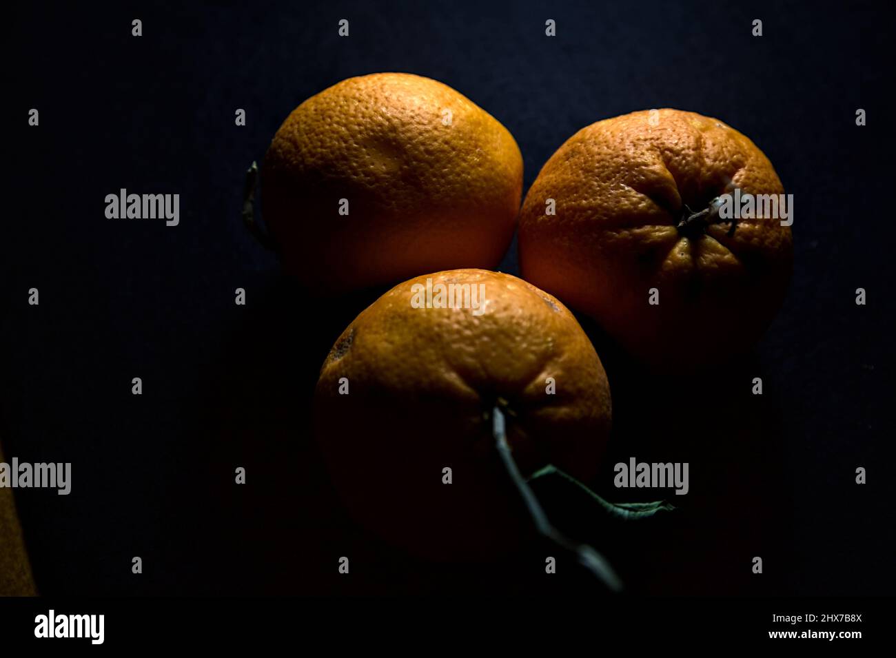 Three oranges on a black background Stock Photo