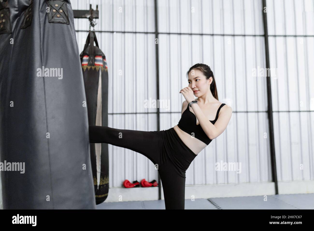 exercise concept The female boxing beginner being firm and giving effort of kicking black boxing