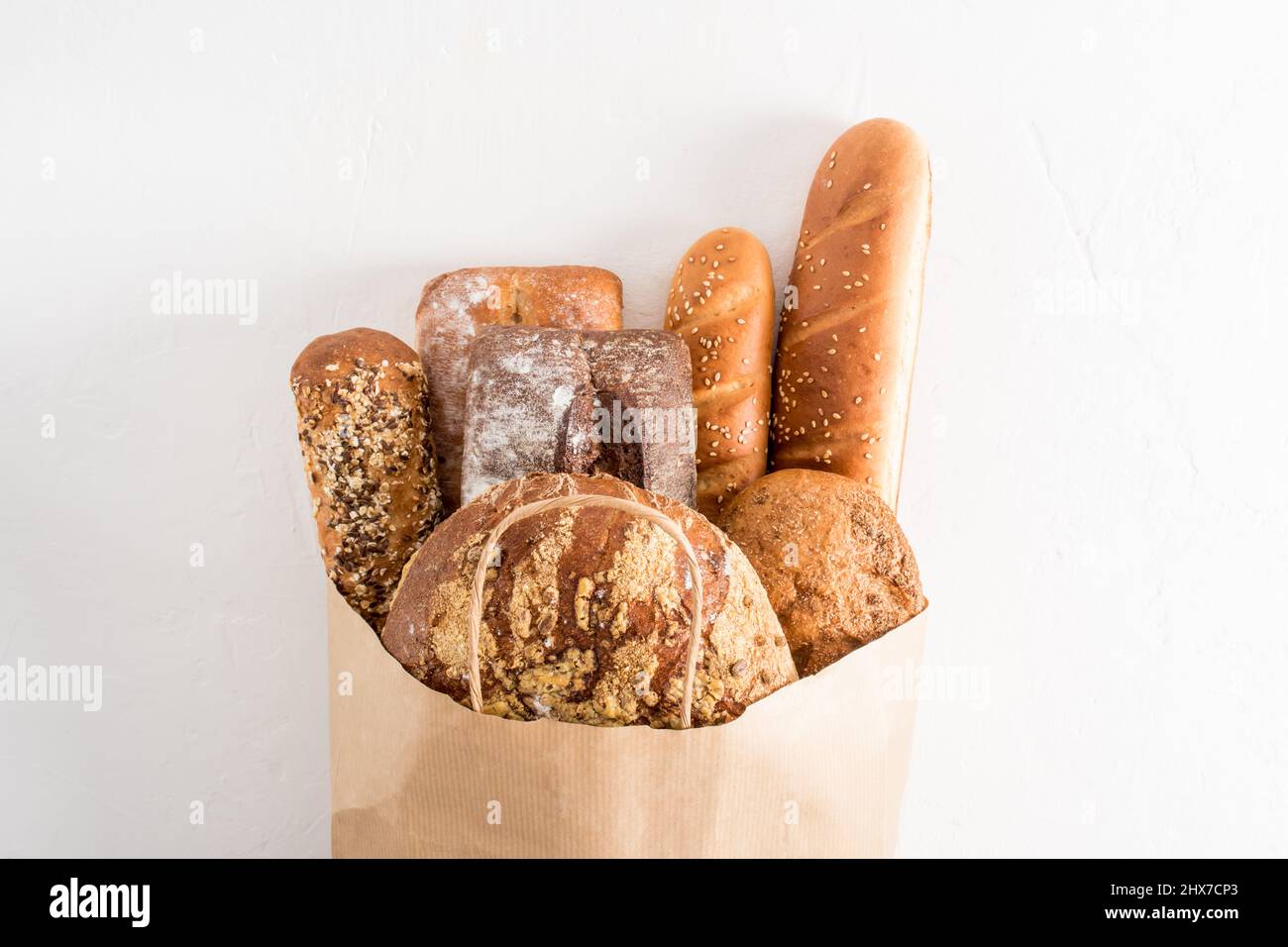 A variety of fresh delicious bread in a paper bag with handles on a ...