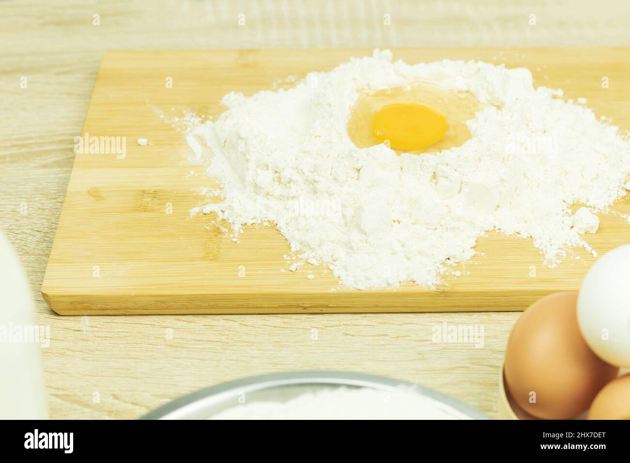 Fresh and raw chicken egg in flour. Bright color of egg yolk and wheat