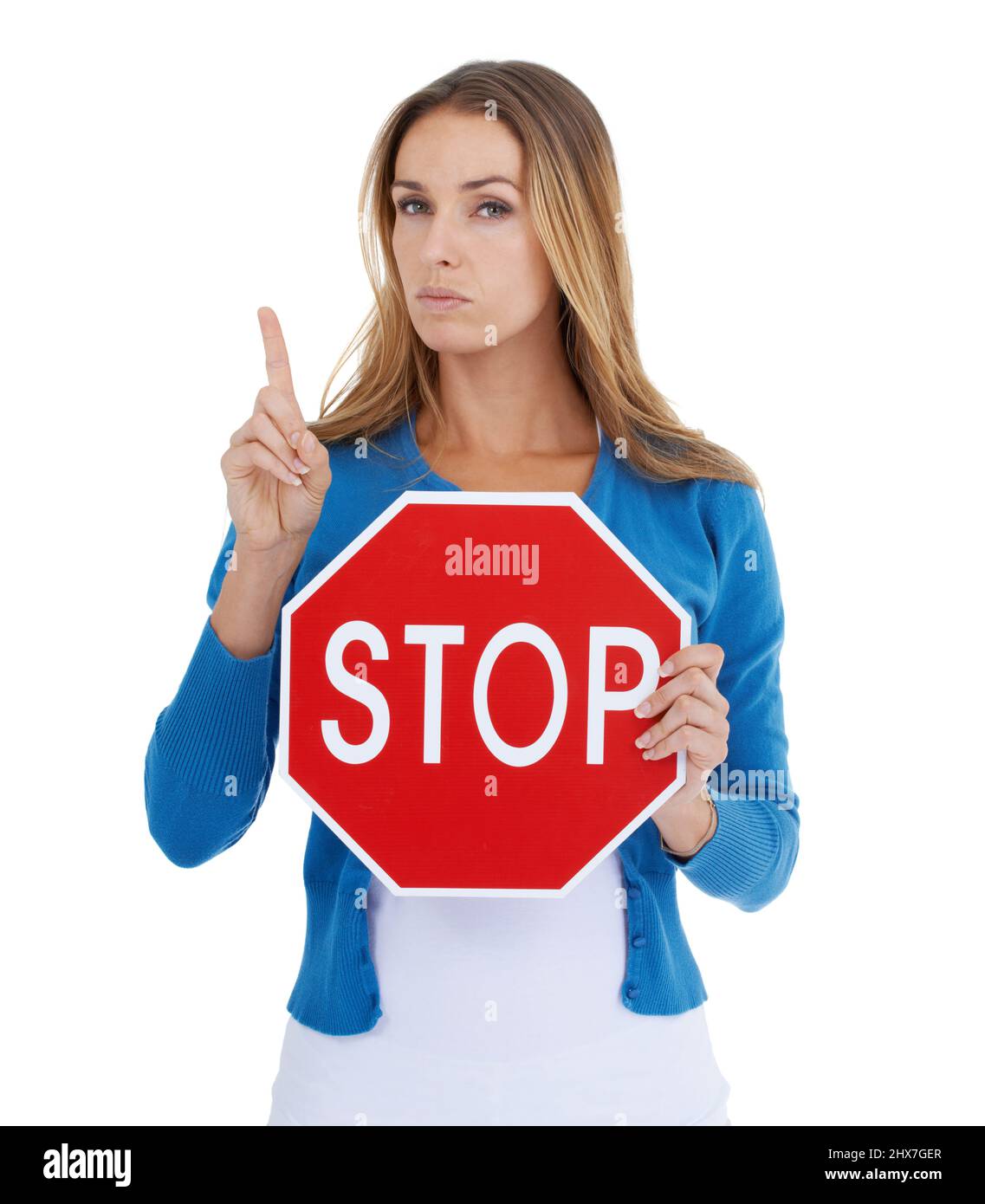 Read the sign. Studio portrait of a stern-looking woman holding a stop sign. Stock Photo