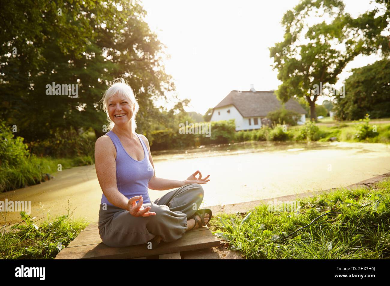 Just enjoying the beauty around her. Shot of an attractive mature woman meditating in a garden at sunset. Stock Photo