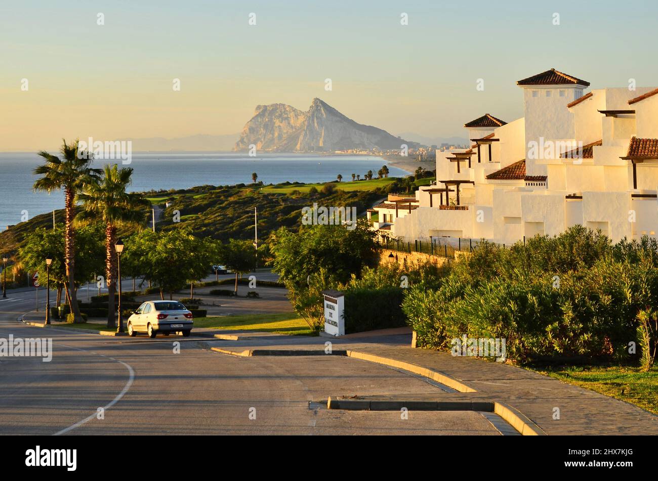 Marina De La Alcaidesa tourist apartments and golf resort with rock of Gibraltar in background, La Alcaidesa Andalusia southern Spain. Stock Photo