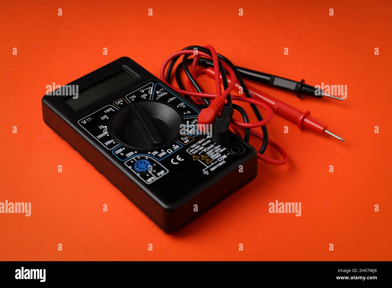 Black multimeter on orange background, close up Stock Photo