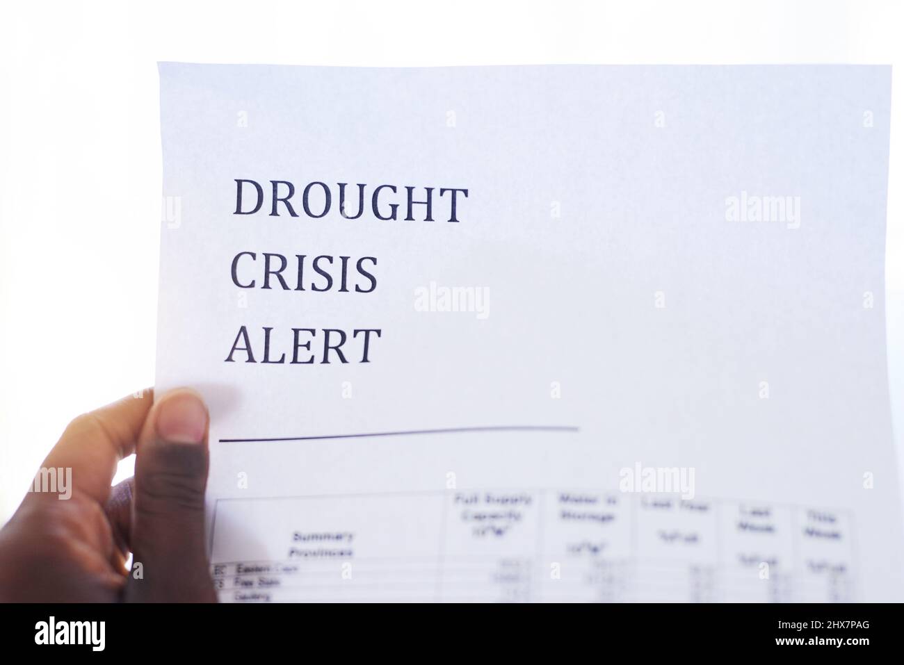 Time to save water. Closeup of an unrecognizable person holding a paper with a notification on it saying drought crisis alert. Stock Photo