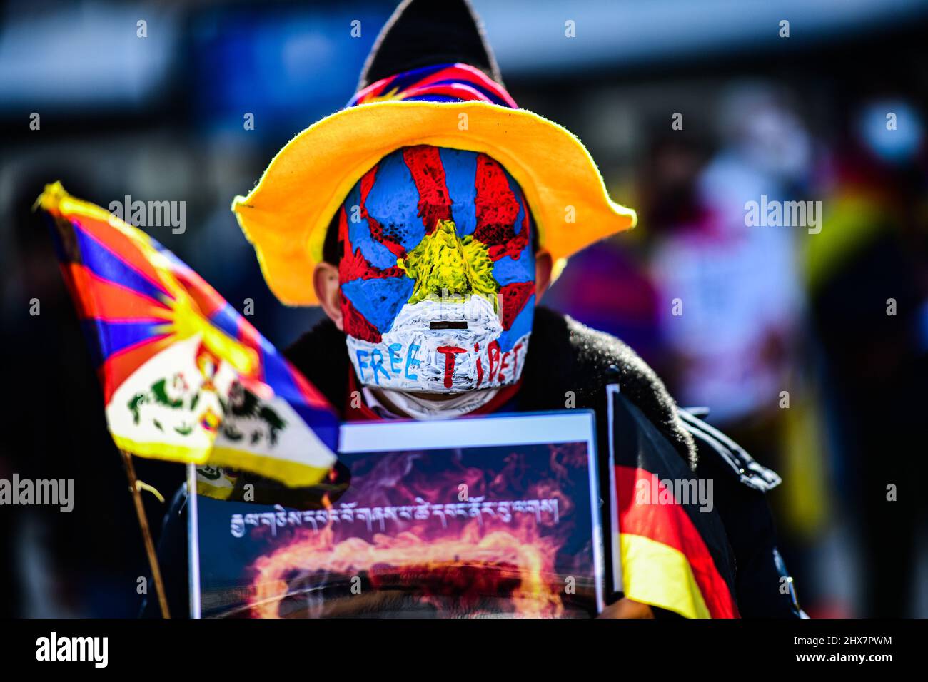Berlin, Germany. 10th Mar, 2022. A man wearing a mask takes part in the demonstration of the Association of Tibetans in Germany (VTD) 'Solidarity for Tibet and Protest for Peace' at Alexanderplatz. Every year on March 10, Tibetans around the world commemorate the Tibetan people's uprising of March 10, 1959, which was bloodily put down by Chinese troops and as a result of which the Dalai Lama had to flee Tibet. Credit: Fabian Sommer/dpa/Alamy Live News Stock Photo