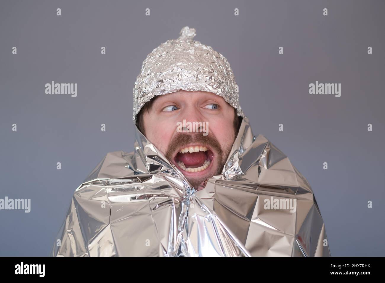 Young man in a cap of foil being afraid and stressed. Stock Photo