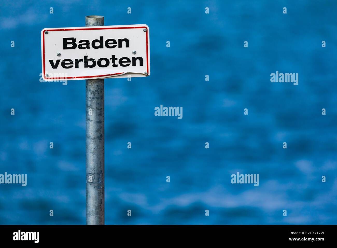 German sign prohibiting bathing with a red border in front of a standing body of water in Germany Stock Photo