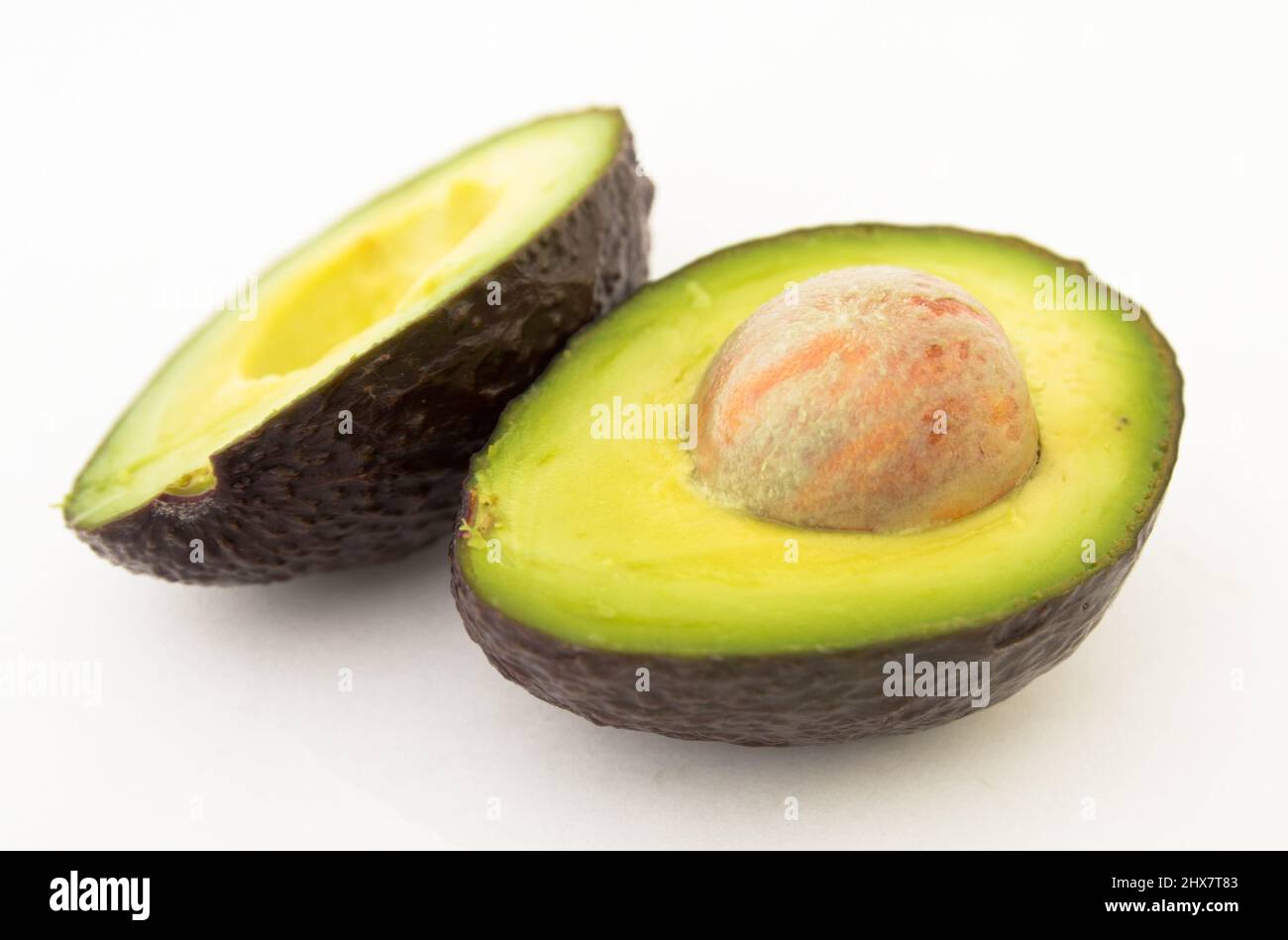 halved avocado with bone on white background Stock Photo