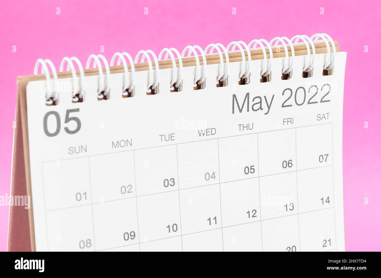 The May 2022 desk calendar on pink background with empty space. Stock Photo