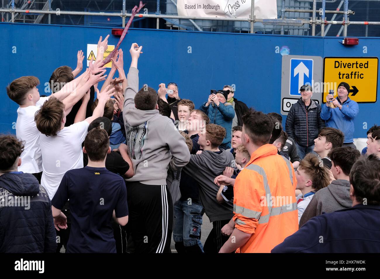 Jedburgh, Thursday 10 March 2022. A group of youths challenge for the 'Ba' 'hailed' during the annual 'Fastern Eve Handba' event in Jedburgh's High Street in the Scottish Borders on March 10, 2022 in Jedburgh, Scotland. The annual event, which started in the 1700's, takes place today and involves two teams, the Uppies (residents from the higher part of Jedburgh) and the Doonies (residents from the lower part of Jedburgh) getting the ball to either the top or bottom of the town. The ball, which is made of leather, stuffed with straw and decorated with ribbons is thrown into the crowd to begin Stock Photo