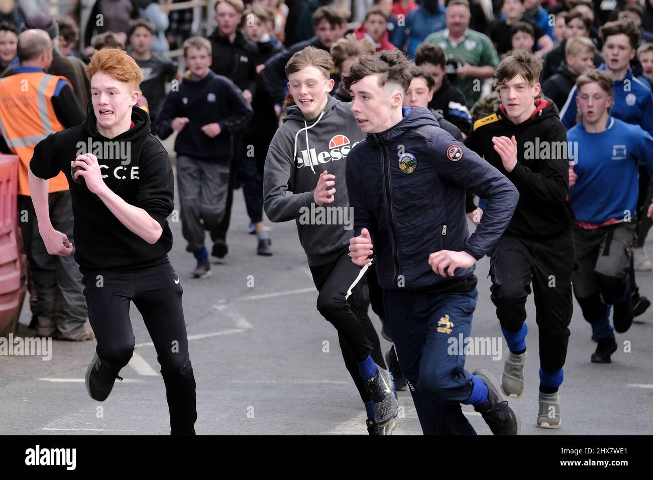 Jedburgh, Thursday 10 March 2022. An unidentified youth with 'Ba' in hand is challenged by others for the 'Schule Ba' the first to be 'hailed' at the start of the annual 'Fastern Eve Handba' event in Jedburgh's High Street in the Scottish Borders on March 10, 2022 in Jedburgh, Scotland. The annual event, which started in the 1700's, takes place today and involves two teams, the Uppies (residents from the higher part of Jedburgh) and the Doonies (residents from the lower part of Jedburgh) getting the ball to either the top or bottom of the town. The ball, which is made of leather, stuffed with Stock Photo