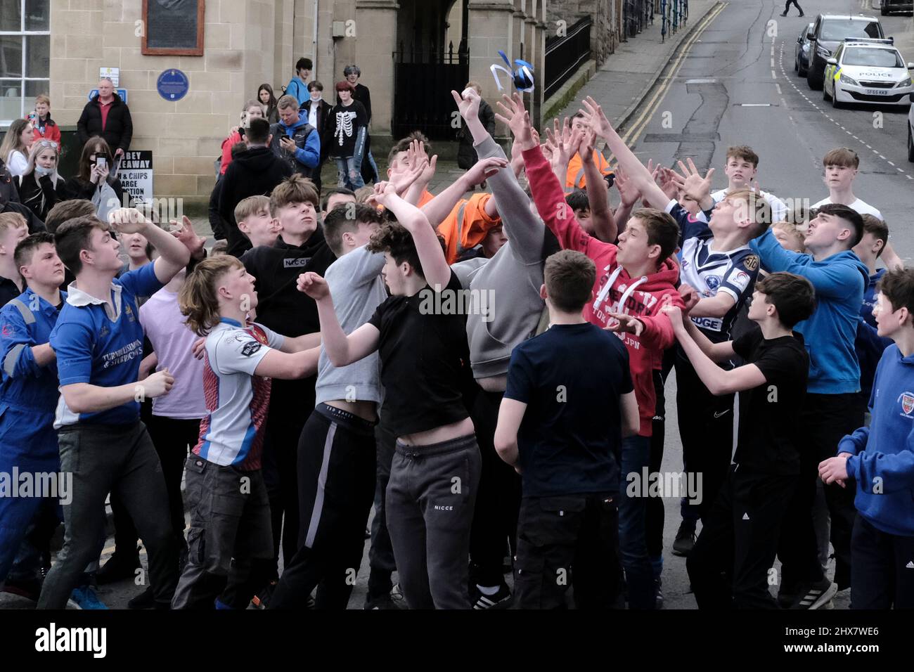 Jedburgh, Thursday 10 March 2022. A group of youths challenge for the 'Ba' 'hailed' during the annual 'Fastern Eve Handba' event in Jedburgh's High Street in the Scottish Borders on March 10, 2022 in Jedburgh, Scotland. The annual event, which started in the 1700's, takes place today and involves two teams, the Uppies (residents from the higher part of Jedburgh) and the Doonies (residents from the lower part of Jedburgh) getting the ball to either the top or bottom of the town. The ball, which is made of leather, stuffed with straw and decorated with ribbons is thrown into the crowd to begin Stock Photo