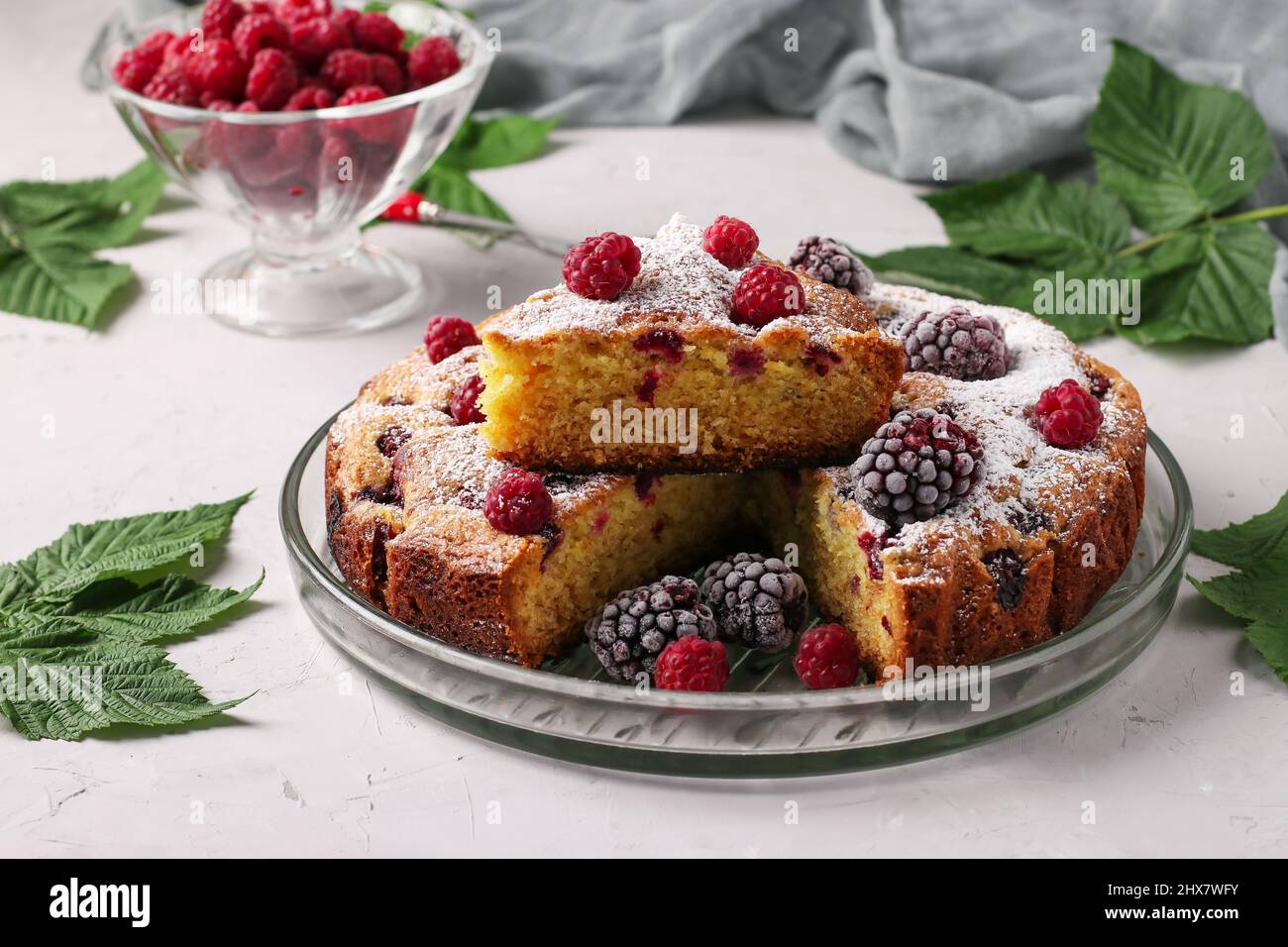 Homemade blackberry and raspberry pie, with piece on plate on light ...