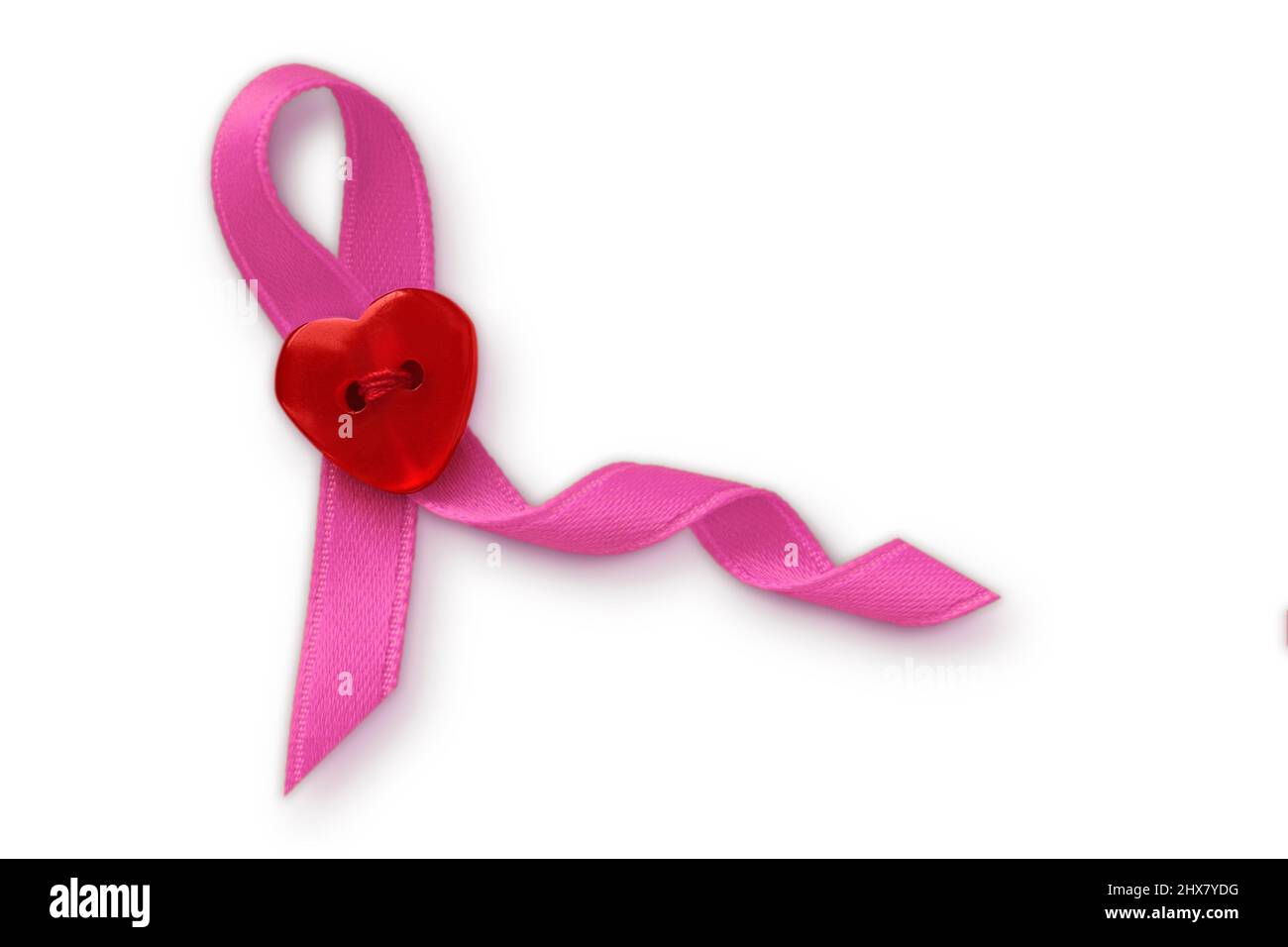 Pink ribbon with heart shaped button on white background - Breast cancer concept Stock Photo
