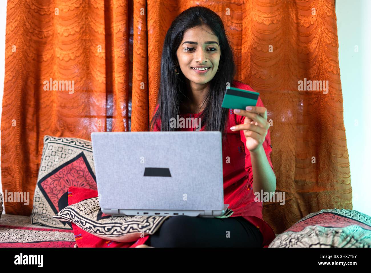 young teenager girl busy shopping online using by making credit card payemt on laptop for purchasing at home - concept of shopaholic, consumerism and Stock Photo