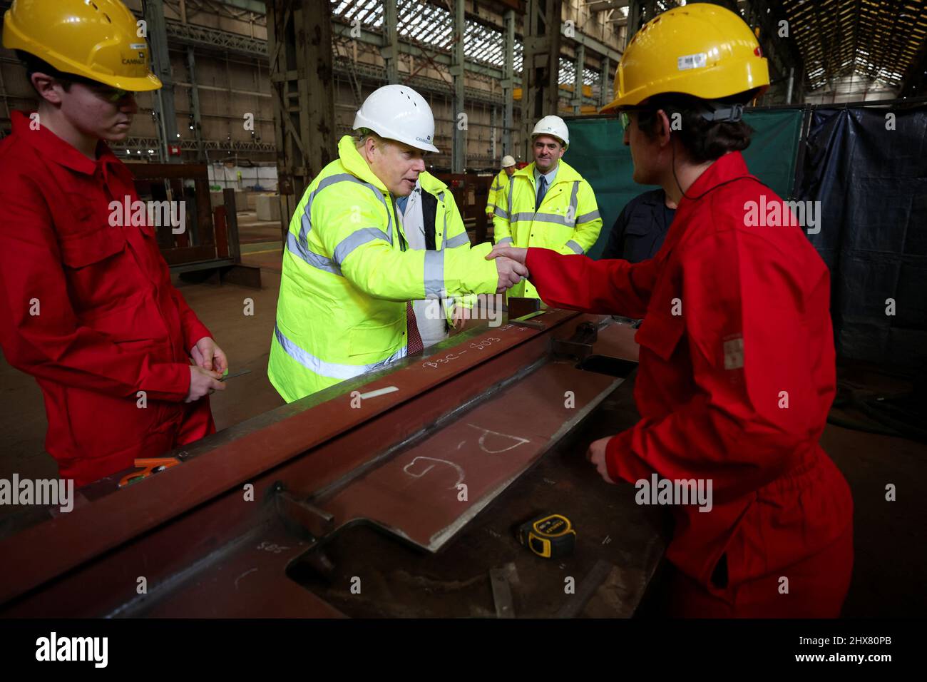 Prime Minister Boris Johnson shakes a worker's hand, at the Cammel Laird shipyard in Merseyside. Picture date: Thursday March 10, 2022. Stock Photo