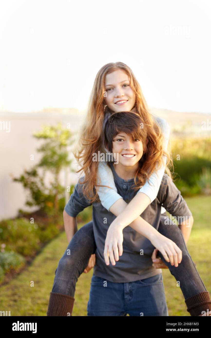 Teenage girl giving friend piggyback ride Stock Photo - Alamy