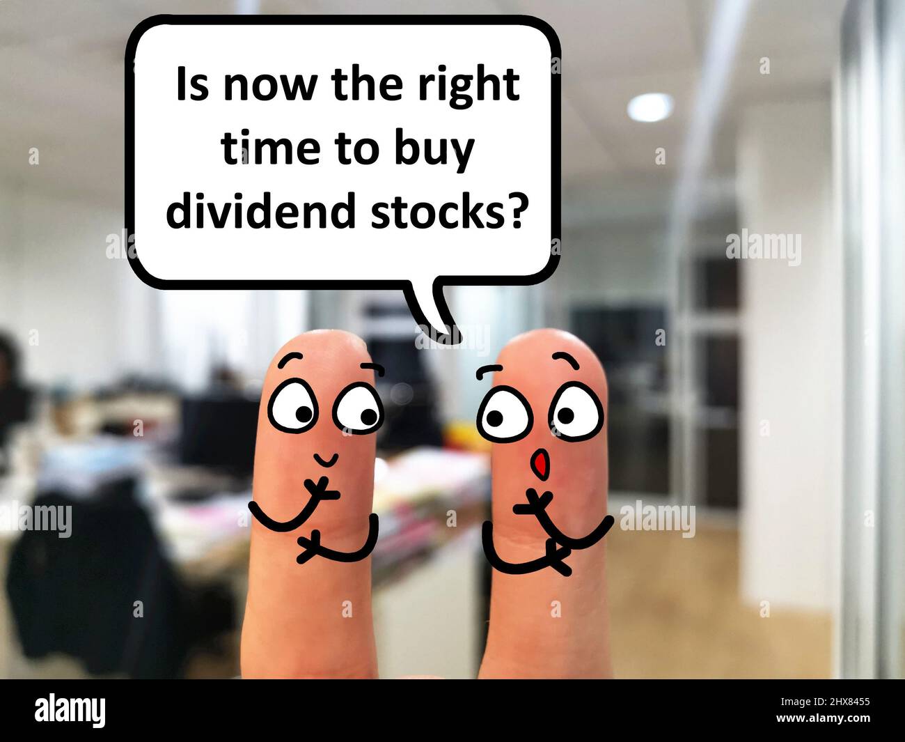 Two fingers are decorated as two person. They are discussing if it is the right time to buy dividend stocks. Stock Photo