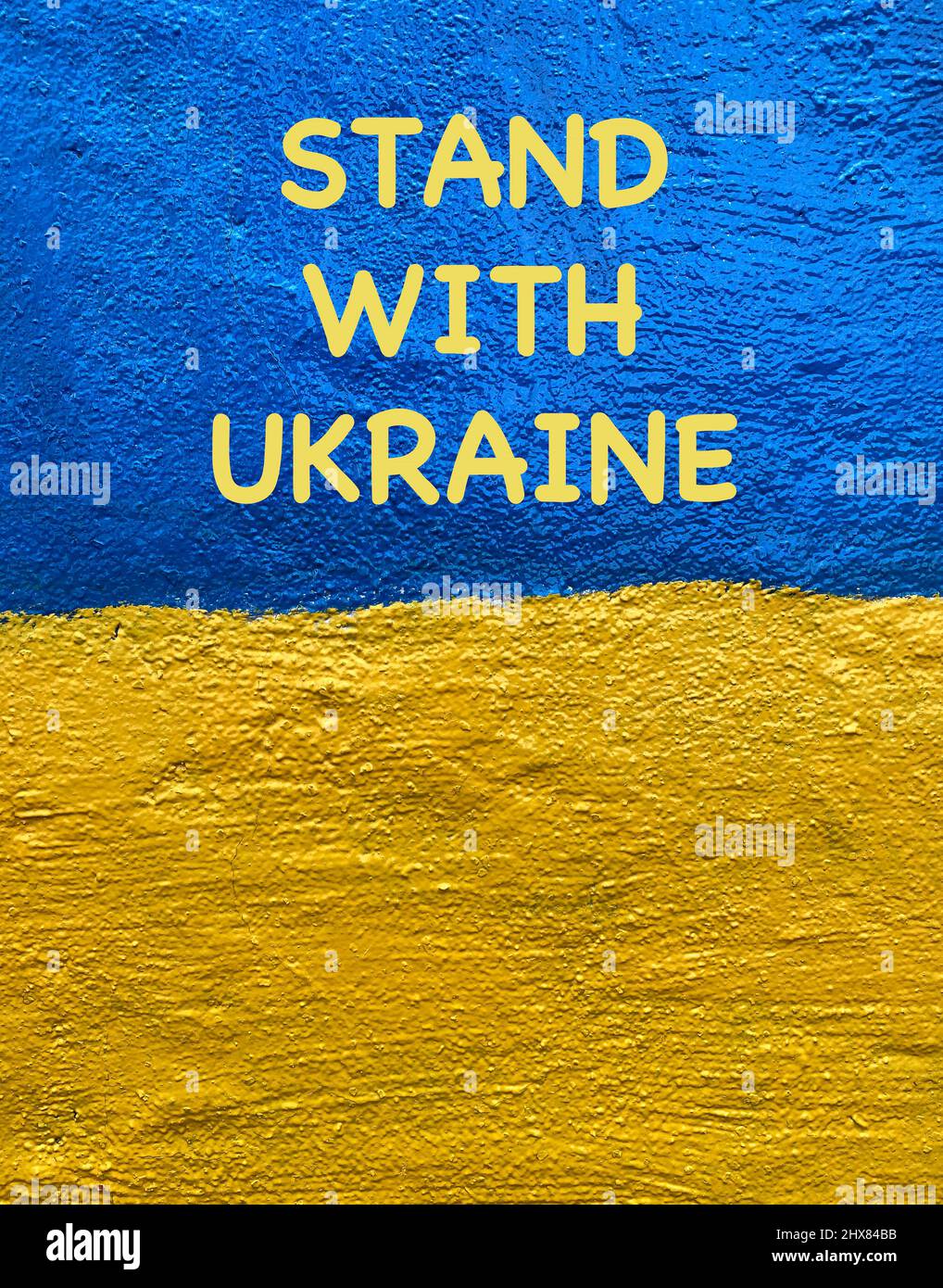 Stand with Ukraine losung on Ukrainian flag painted on wall Stock Photo
