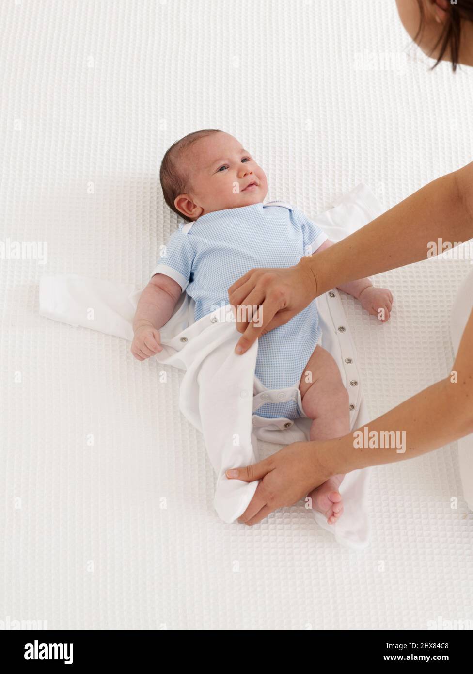 Dressing baby boy in babygro, 6 weeks Stock Photo Alamy